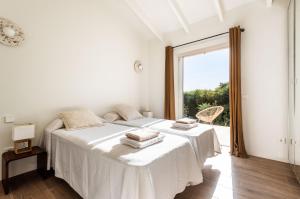 two beds in a white room with a window at Horizonte Sur in Binibeca +26 photos