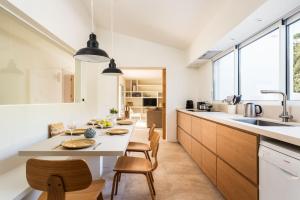 a kitchen with a table and chairs and a kitchen with windows at Horizonte Sur in Binibeca