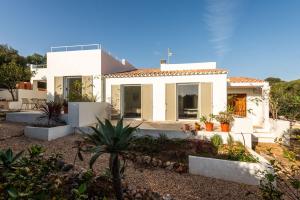 a white house with plants in front of it at Horizonte Sur in Binibeca
