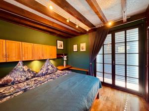 a bedroom with a bed and a large window at The red House in Schönecken