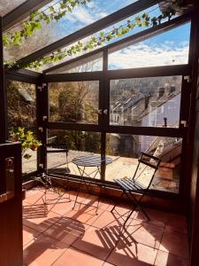 a patio with two chairs and a table in front of a window at The red House in Schönecken