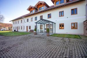 a large white building with a brick driveway at Haus am Hof in Kirchseeon