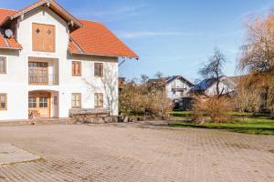 a white house with an orange roof and a brick road at Haus am Hof in Kirchseeon