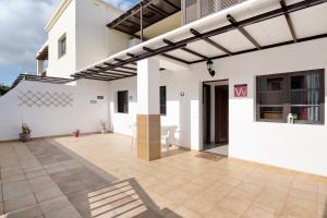 a white house with a patio with awning at Casa Candido 2 in Playa Honda