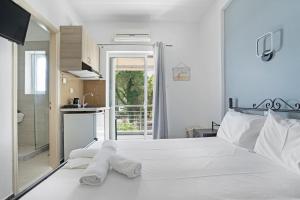 a bedroom with a white bed with towels on it at Iguana studio 7 in Preveza