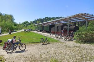 a group of people riding bikes next to a train at Bahnhof Durlesbach in Bad Waldsee