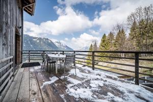 a table and chairs on a wooden deck with snow at Martonne Terrasse chatel Roca in Châtel