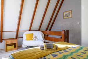 a bedroom with a bed and a chair with a teddy bear at Gite Gewurz n°4 à Kaysersberg in Kaysersberg