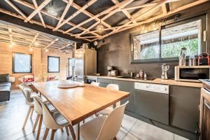 a kitchen with a wooden table and chairs at Martonne Terrasse chatel Roca in Châtel