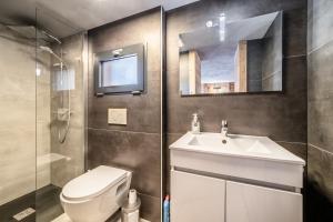 a bathroom with a toilet and a sink and a mirror at Martonne Terrasse chatel Roca in Châtel +15 photos