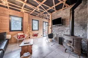 a living room with a fireplace and a stone wall at Martonne Terrasse chatel Roca in Châtel