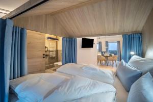 a bedroom with two beds and a table with a television at Avia Living Maria in Brunico