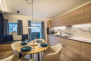 a kitchen with a wooden table and chairs and a dining room at Avia Living Maria in Brunico