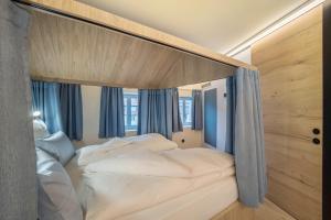 a bedroom with a large bed with white sheets at Avia Living Maria in Brunico