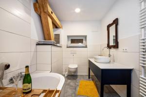 a bathroom with a tub and a sink and a toilet at Salerhof in Bad Wurzach