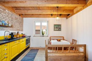 a kitchen with yellow cabinets and a table at Salerhof in Bad Wurzach