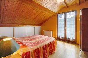 a bedroom with a bed and a large window at La Grange Villard in Albiez-Montrond
