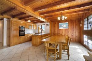 a kitchen with a wooden table and chairs at La Grange Villard in Albiez-Montrond