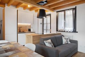 a living room and kitchen with a couch and a table at Sogno Alpino in Caspoggio +23 photos