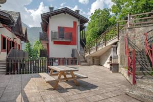 a wooden picnic table in front of a building at Sogno Alpino in Caspoggio