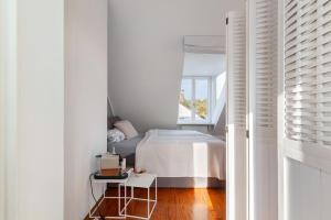 a white bedroom with a bed and a window at Skyline-Blick in Bad Soden am Taunus