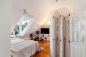 a white bedroom with a bed and a window at Skyline-Blick in Bad Soden am Taunus