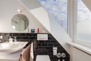 a bathroom with a sink and a mirror at Skyline-Blick in Bad Soden am Taunus +14 photos