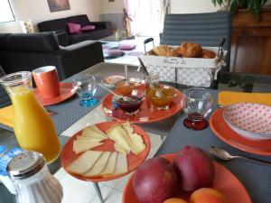 a table with plates of fruit and a basket of bread at La Chambre aux Oiseaux in Cayriech