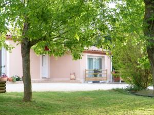 a pink house with a bench in a yard at La Chambre aux Oiseaux in Cayriech