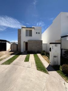 a white house with a garage and a driveway at Casaaurea in Jesús María