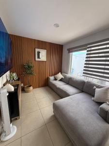 a living room with a couch and a window at Casaaurea in Jesús María