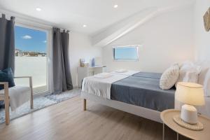 a bedroom with a bed and a large window at Ocean City View Loft in Ponta Delgada