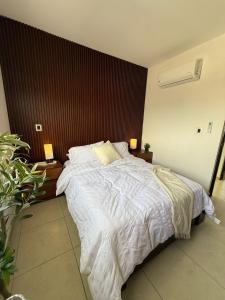 a bedroom with a large bed with white sheets at Casaaurea in Jesús María +16 photos
