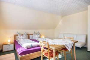 a bedroom with two beds and a table and a table and chairs at Haus Zapf in Kressbronn am Bodensee