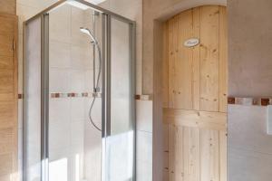 a shower with a glass door in a bathroom at Ferienwohnungen am Hofgarten in Krün +40 photos