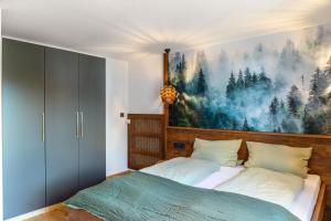 a bedroom with a bed with a painting on the wall at Ferienwohnungen am Hofgarten in Krün