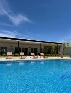 a large swimming pool with chairs and a building at Casaaurea in Jesús María