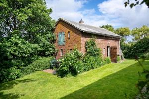 an old brick house in a yard with a lawn at Fewo Silke Dethlefsen in Pellworm
