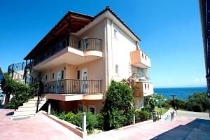 ein Gebäude mit Balkonen und dem Meer im Hintergrund in der Unterkunft Effie's House in Ágios Nikólaos