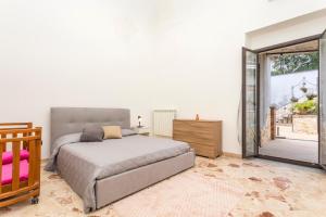 a bedroom with a bed and a sliding glass door at La Papuzzella in Puntalazzo