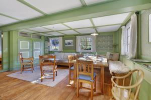 a dining room with green walls and a table and chairs at Bachrainhof 2 in Menzenschwand
