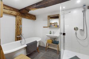 a bathroom with a bath tub and a sink at Bachrainhof 2 in Menzenschwand +28 photos