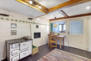 a kitchen with a stove and a table and a door at Bachrainhof 2 in Menzenschwand