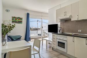 a kitchen and living room with a table and chairs at Barlovento Apartment in Playa Honda