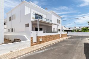 a white house with a street in front of it at Barlovento Apartment in Playa Honda