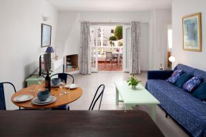 a living room with a blue couch and a table at Bright spacious 1 bed apartment in Nerja