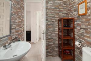 a bathroom with a sink and a brick wall at Bright spacious 1 bed apartment in Nerja +20 photos