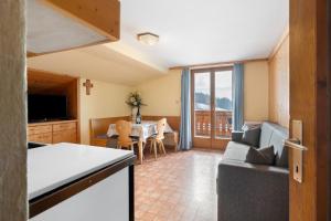 a kitchen and living room with a table and a couch at Haus Prossliner in Tesimo