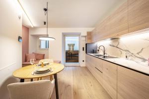 a kitchen with a table and a dining room at Avia Living Anna in Brunico