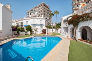 a swimming pool in front of a building at Bright spacious 1 bed apartment in Nerja